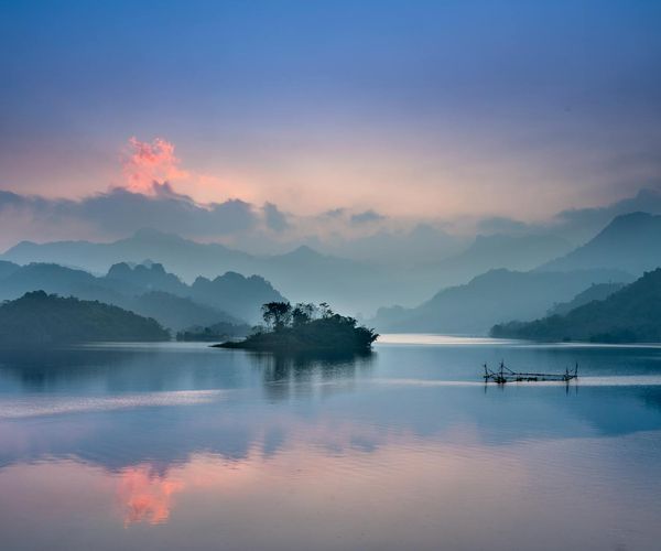 Serene natural landscape with a calm lake at sunrise.